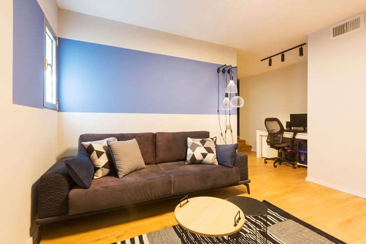 צבע הקיר מגדיר את אזור הספה בעיצוב יחידת מגורים לנער.